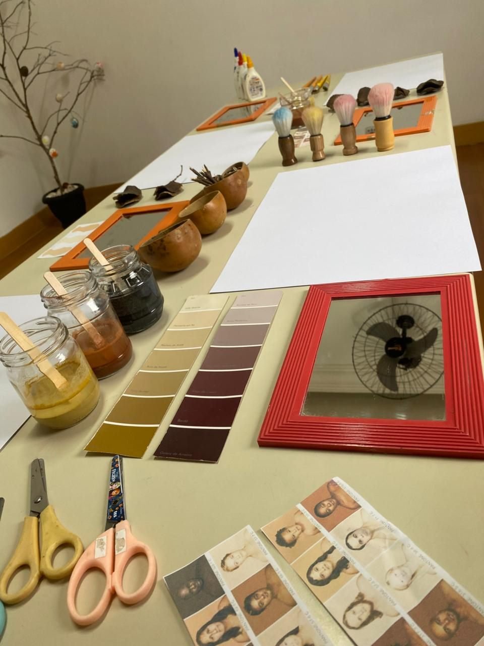Ateliê preparado com tintas, espelho e elementos naturais