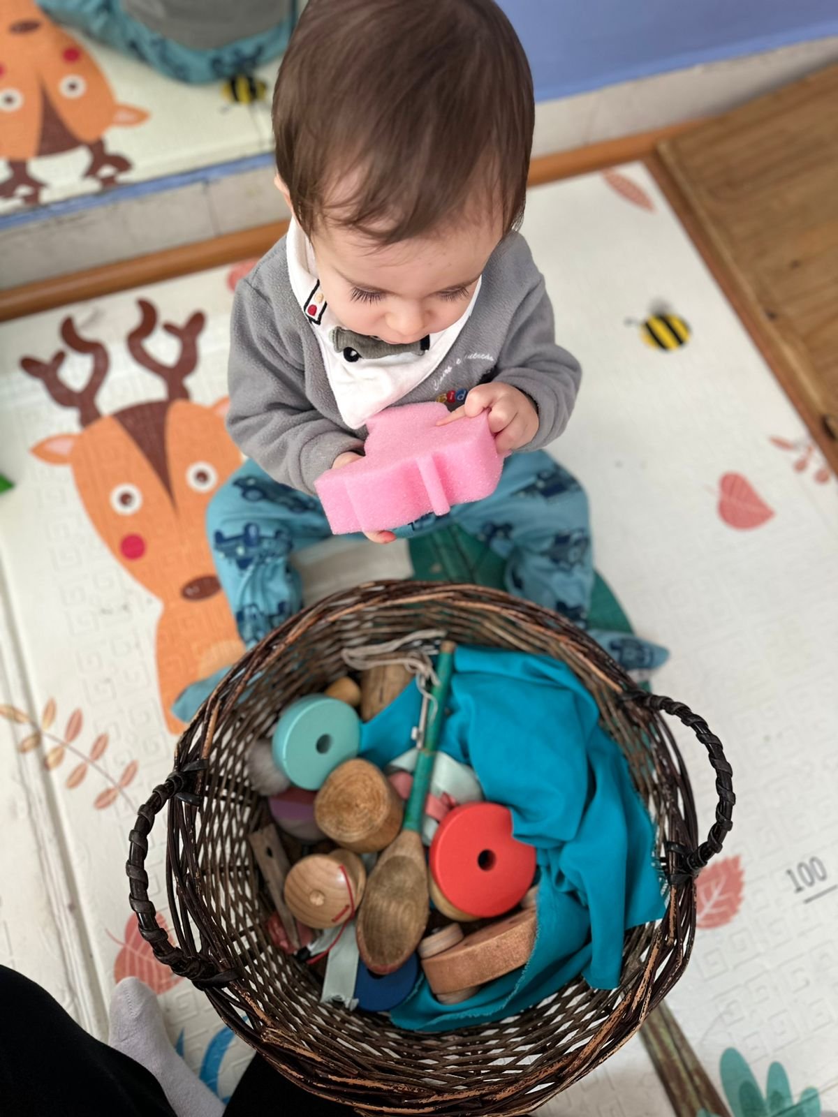 Bebê explorando objetos de um cesto dos tesouros