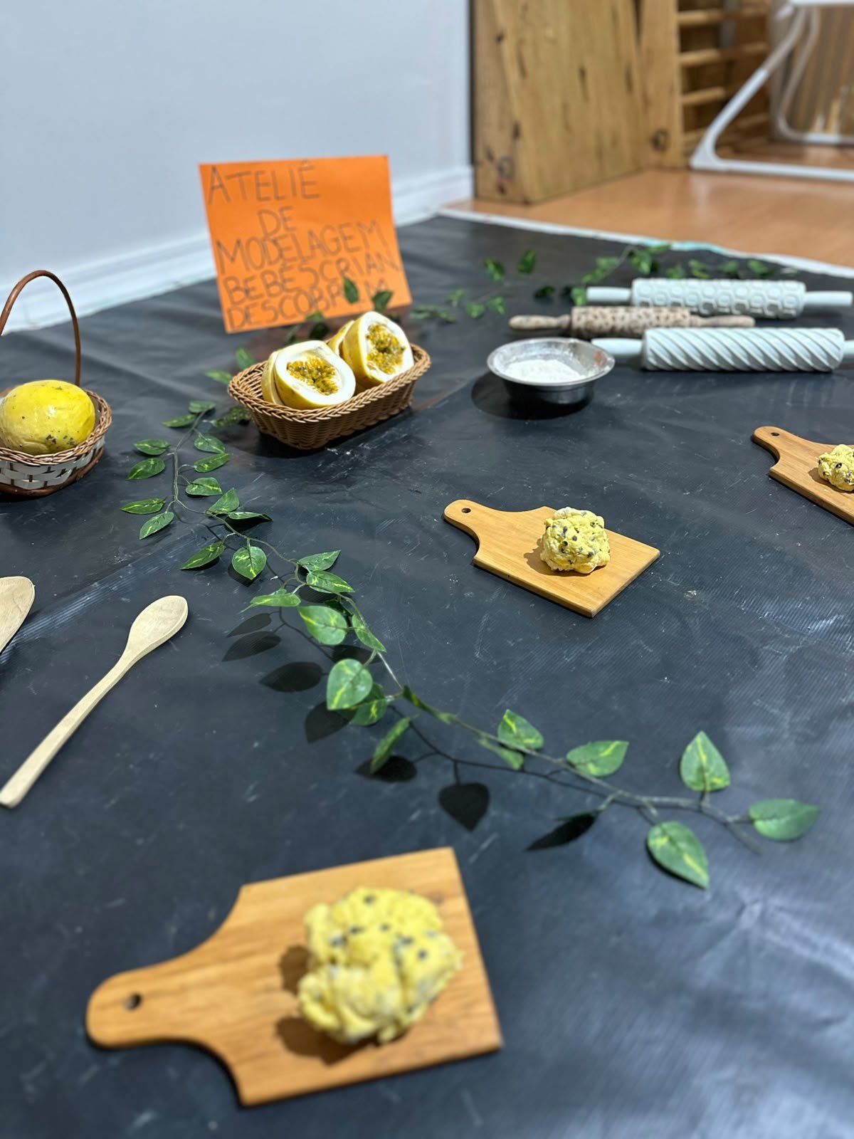 Ateliê de modelagem preparado para os bebês, com maracujás, tábuas e rolinhos