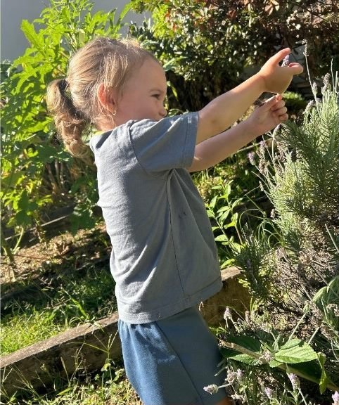 Menina cheirando a lavanda no jardim